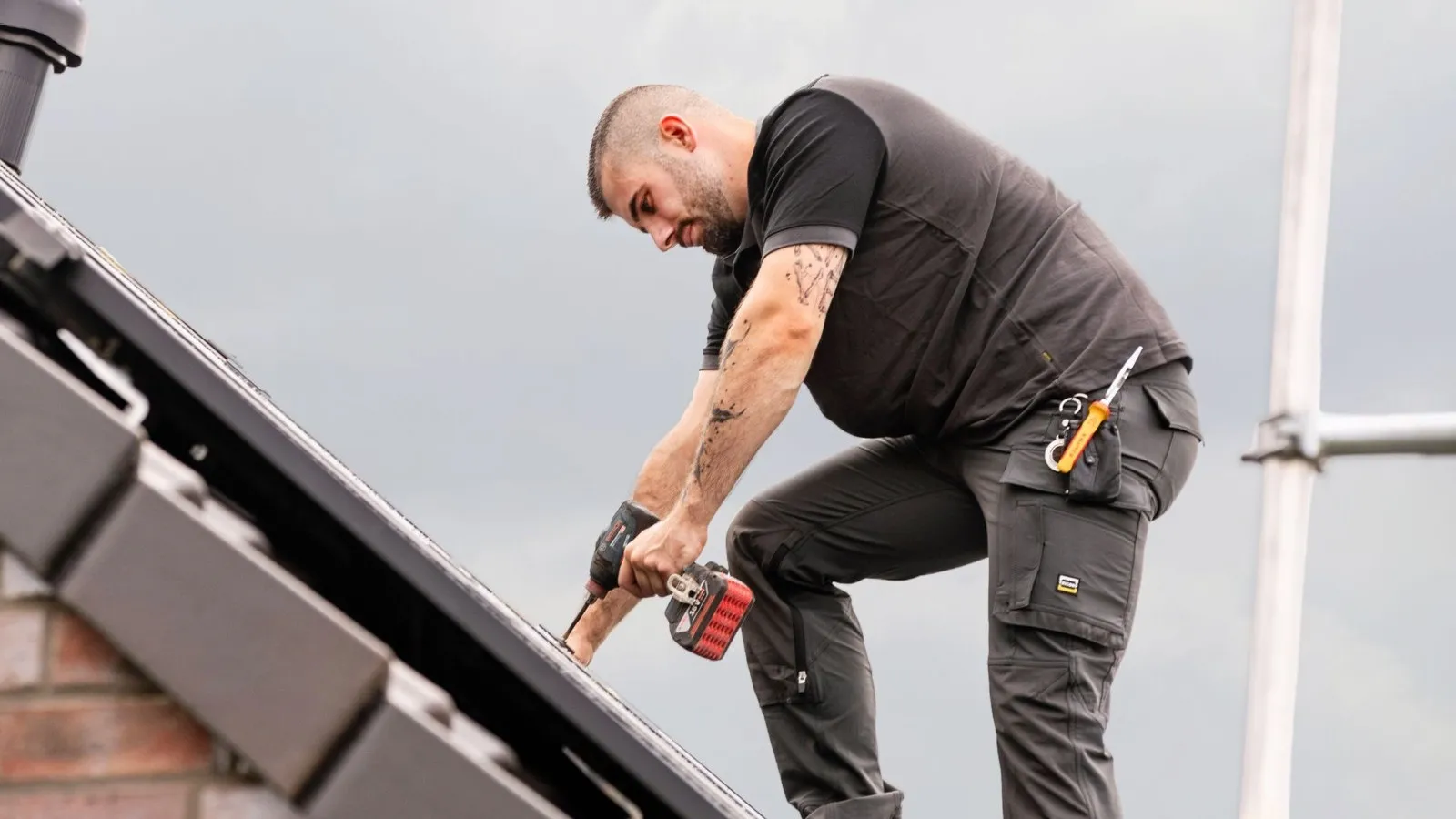 Foto von Kevin Josef Schlebusch, Elektrotechniker-Meister und Betriebsinhaber, während er auf einem Dach arbeitet.